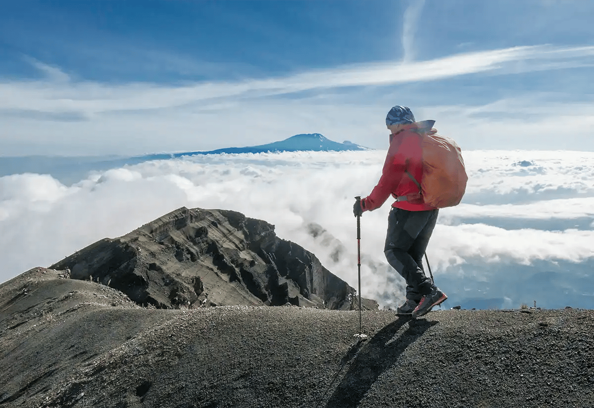 Person walking a mountain peak July